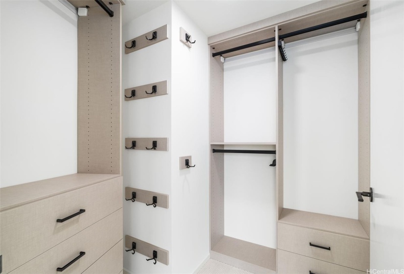 Master bedroom features a custom-built walk-in closet with full wardrobe and drawer space.