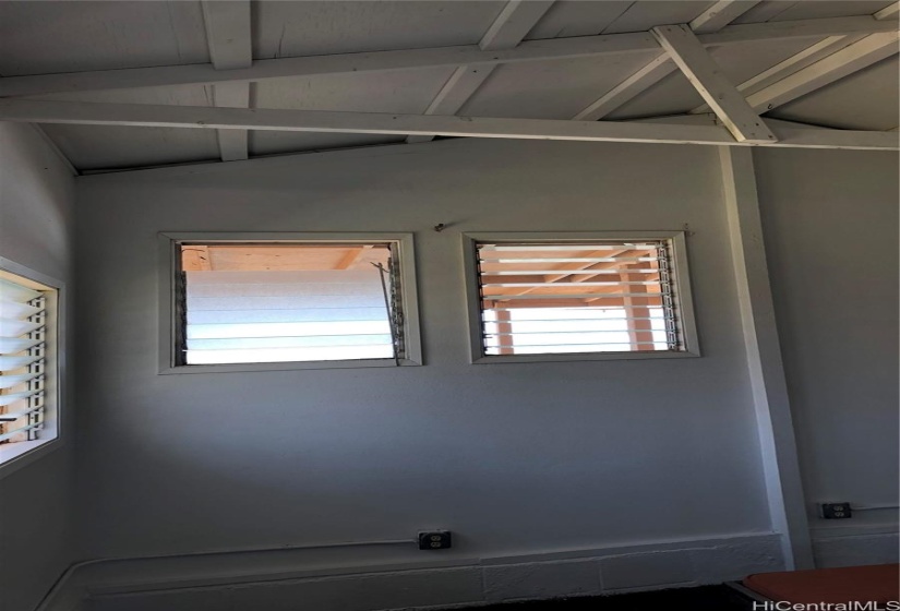 Studio vaulted ceiling showing the lanai cover next to the ocean.  Some windows have been changed out.