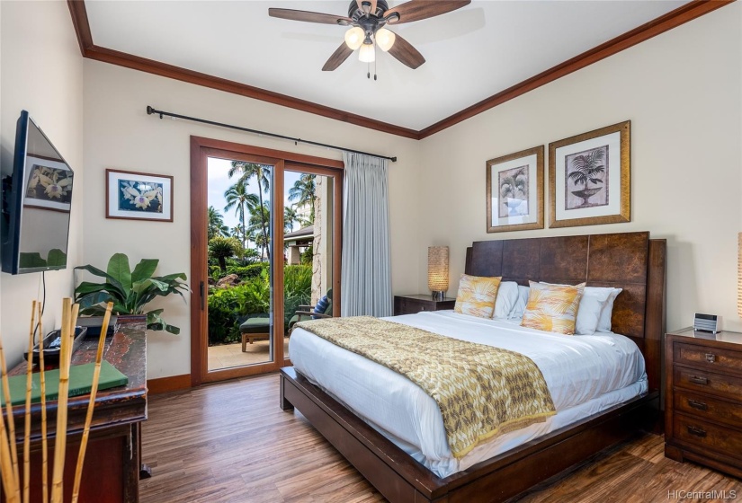 Master Suite with new luxury vinyl flooring, beautiful king-size bed, ceiling fan, central AC, wall-mounted TV and direct outdoor lanai access.