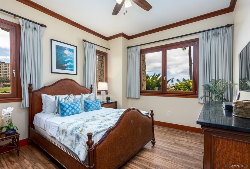 Second Master Suite at the other end of the Villa, with new luxury vinyl flooring, queen-size bed, ceiling fan, several windows, black-out curtains, wall-mounted TV, large closet space.