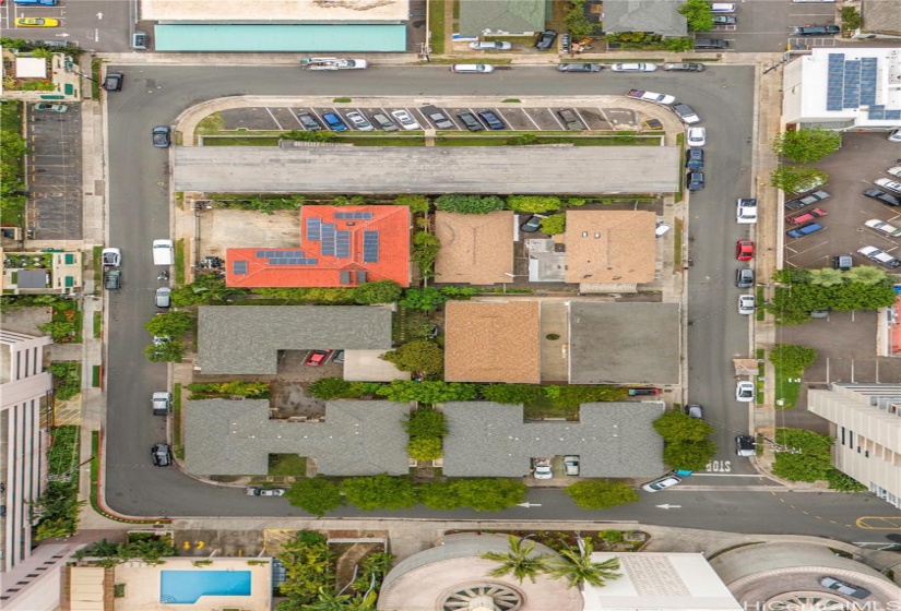 The building is the top of the block with sidewalks and extra parking around.