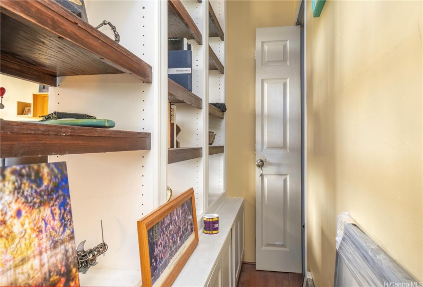 Backside of bookshelf and walkway to closet