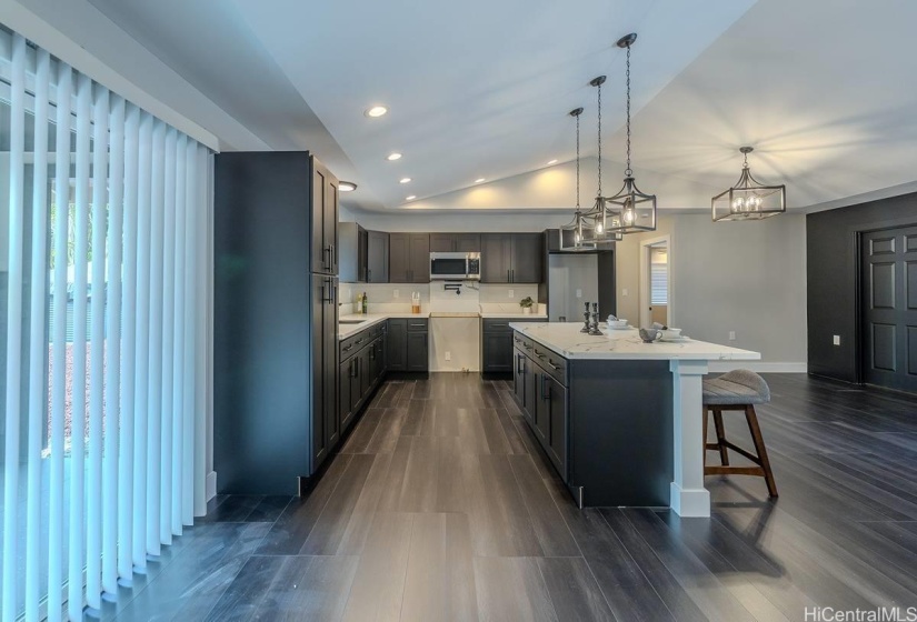 The dark kitchen cabinets are all soft closing and blends well with the flooring and accent wall.