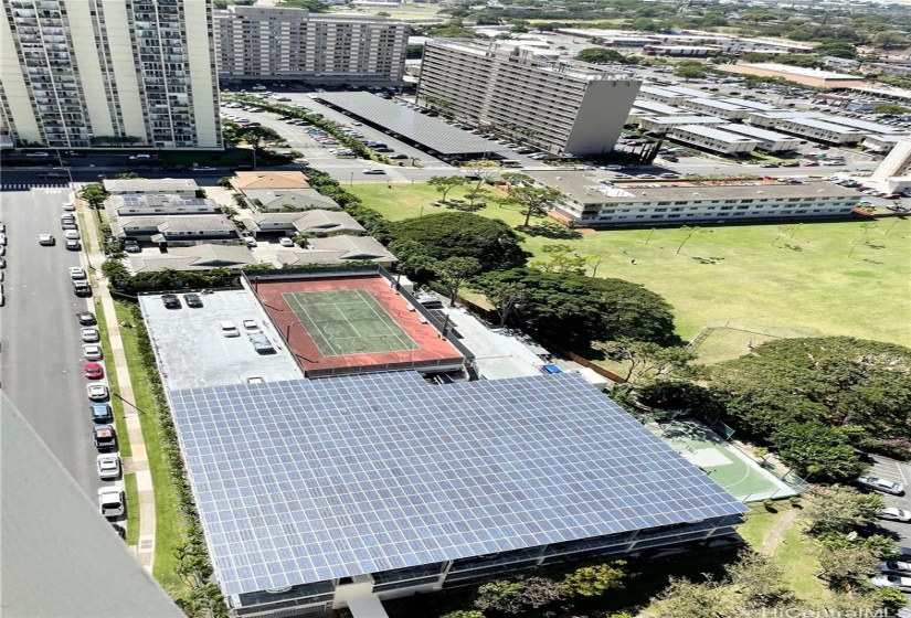 View from 2nd bedroom looking down to parking structure with PV on roof and tennis court.