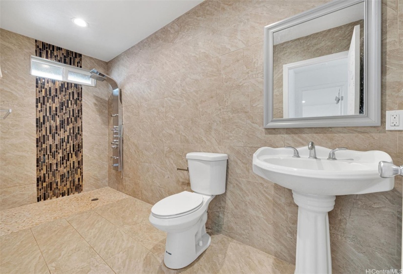 The second bathroom has ceramic tiles up to the ceiling.