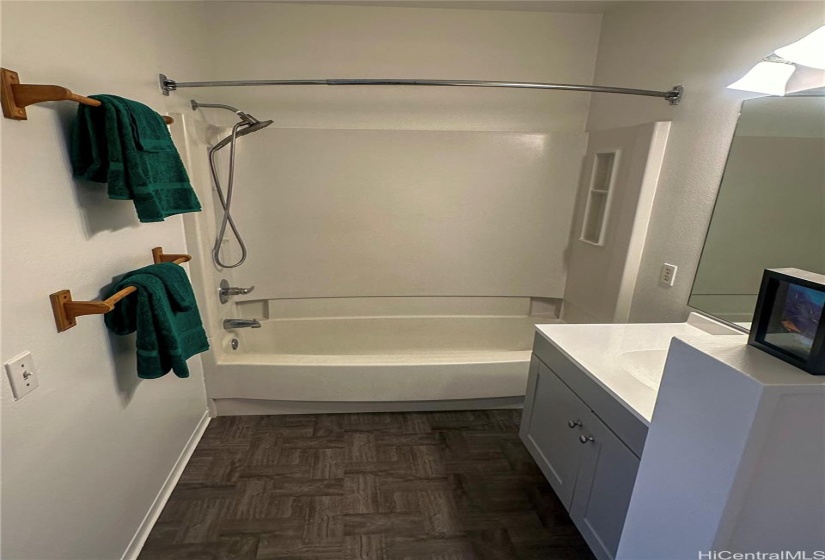 En-suite #2. Sink, towel racks, bathtub, shower head, and ventilation system.