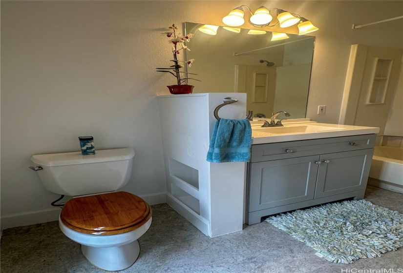 En-suite #1. Brightly lit bathroom with Vinyl flooring, toilet, and sink.