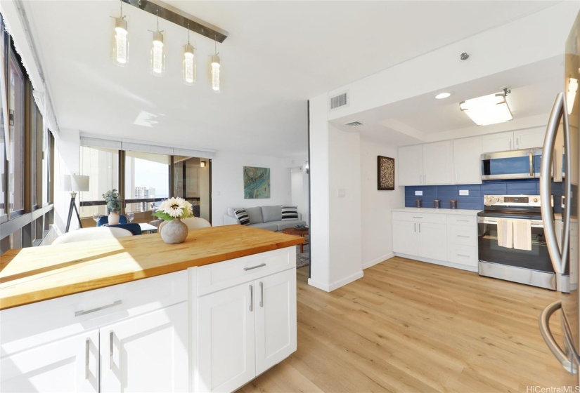 View of kitchen, island, and into living room, lanai doors visible here.