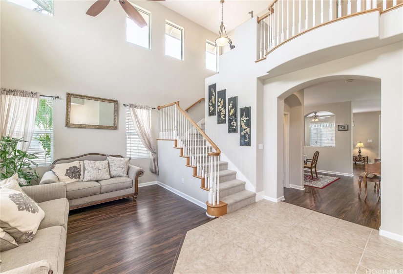 Living room view, high ceiling area, staircase and entry.