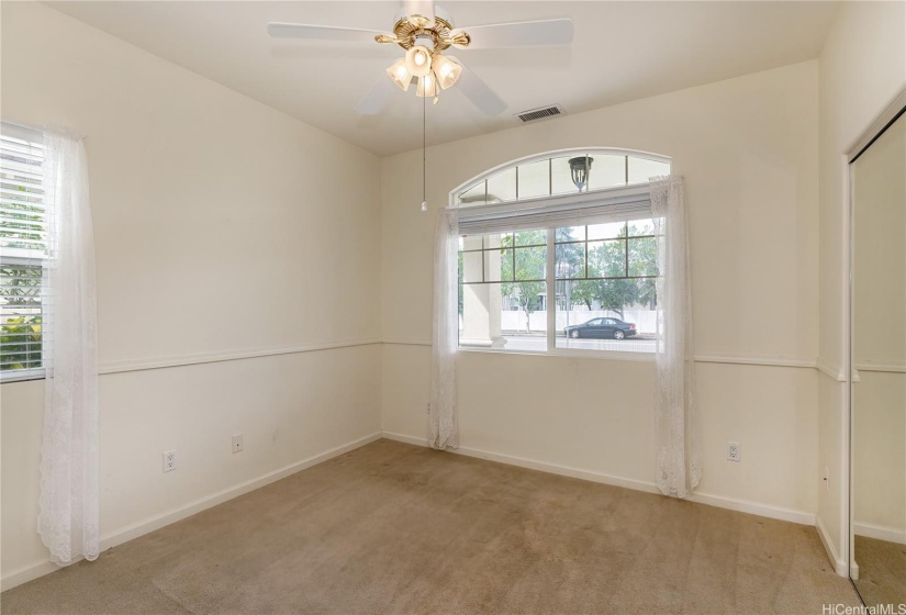 Downstairs bedroom with mirrored closet sliding doors.