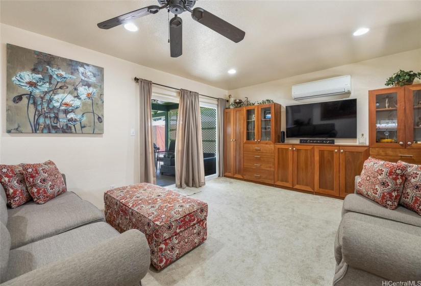 Living Room - Built-In Cabinets, Split AC, Ceiling Fan, Area Rug, and Ceramic Tile Flooring.