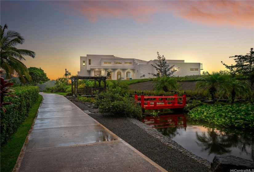 View of the Koi pond stocked with over 100 live koi fish and tilapia looking onto the property and a portion of the almost-mile long concrete road build for a stable walking path.