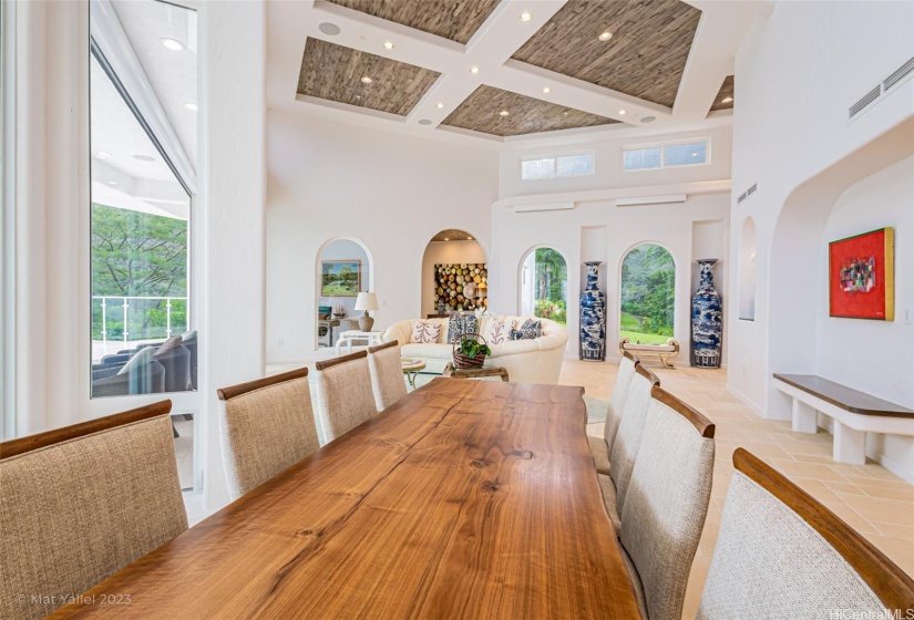 Expansive dining room looking into the main living area and outside to the infinity pool.