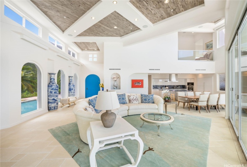 Alternative view of the main living area looking toward the striking blue front entrance, kitchen, and third floor sitting area.