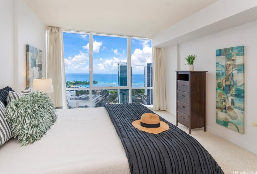 Primary bedroom with floor to ceiling windows and views.