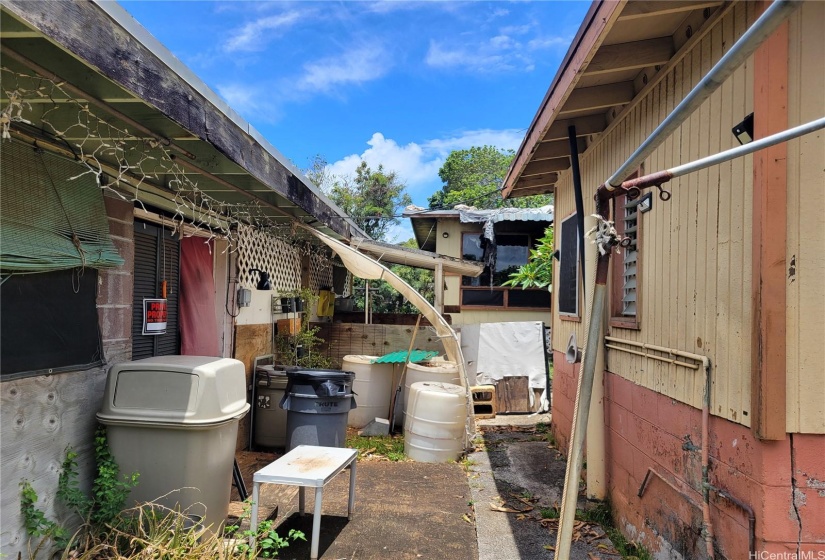 view of carport to the left, front house to the right and back house in the middle