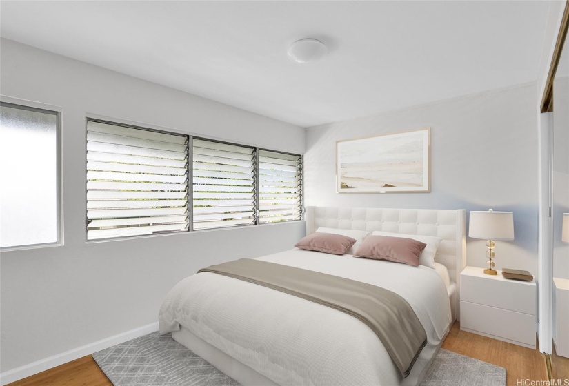 Second bedroom with mirrored closet doors and generous windows offering natural light.