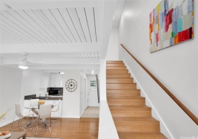 Staircase up leads to a 2nd bathroom and 2 bedrooms. Photo shows virtual staging.