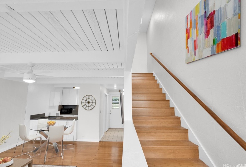 Staircase up leads to a 2nd bathroom and 2 bedrooms. Photo shows virtual staging.