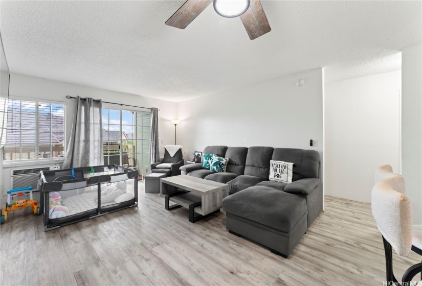 view of the living area, hallway to the rooms on the right and door to the balcony on the left.