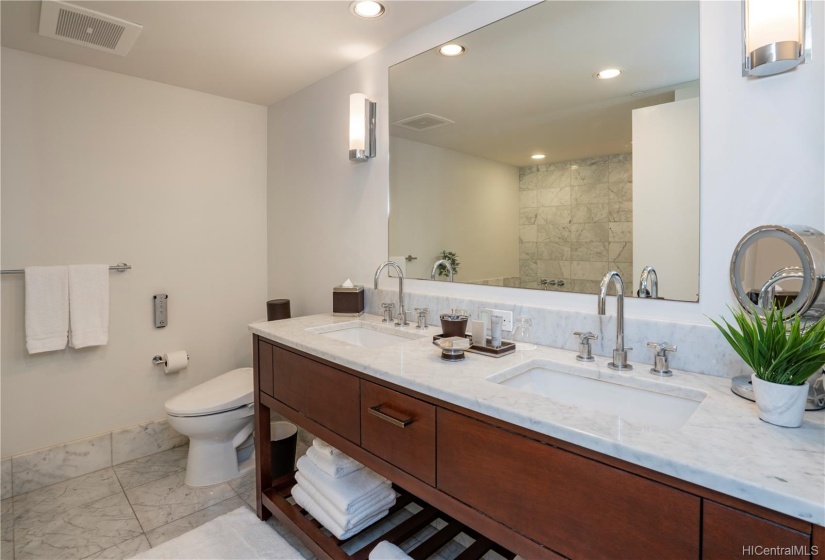 Luxurious, large marble bathroom with double sink and deep soak-in tub.