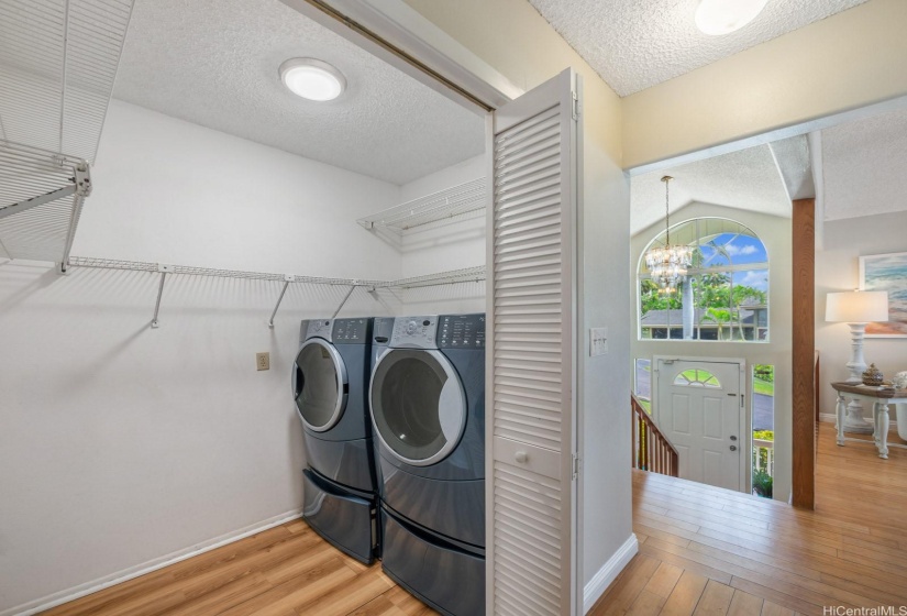 Set back in a separate room in the hallway heading to the three upstairs bedrooms is the laundry room with large capacity washer and dryer.