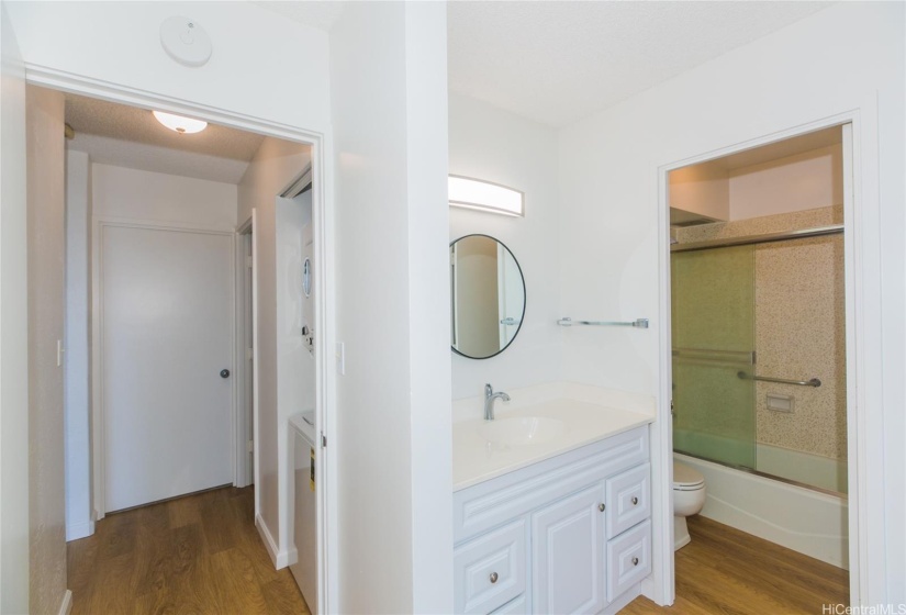 a closer look at the primary bathroom and the washer/dryer in the hall to the left