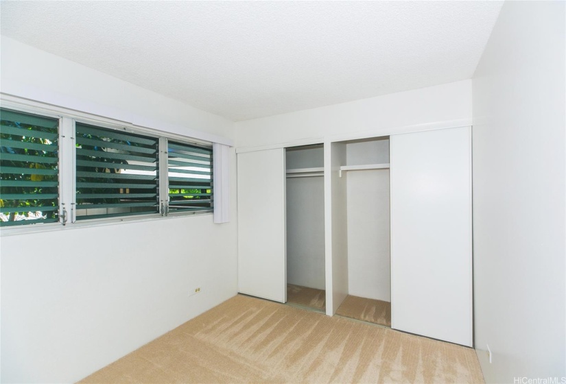 2nd bedroom that has ample closet space with good air flow from open windows