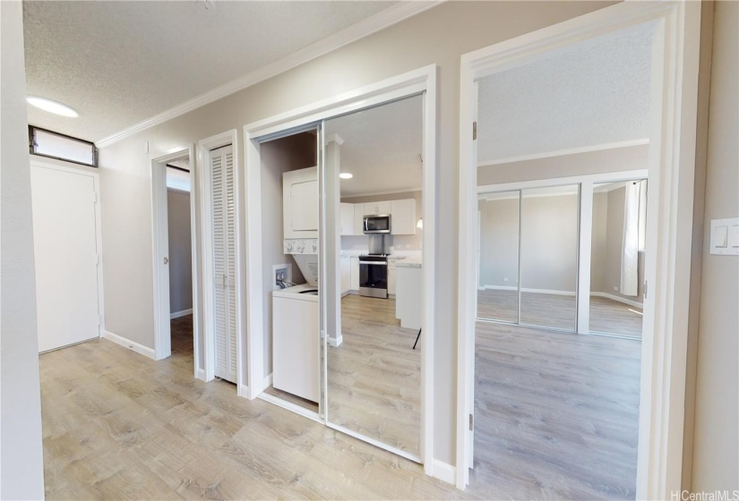 Hallway closet with stackable washer & dryer and hot water heater.