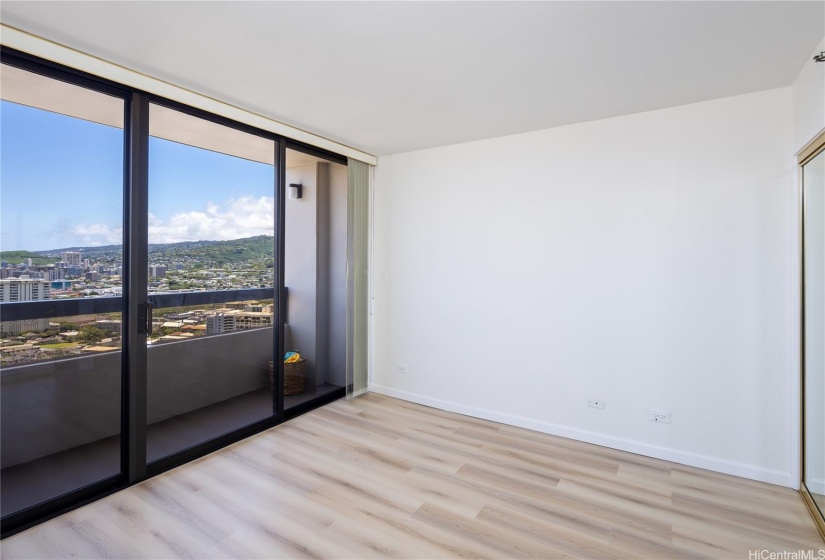 New Luxury vinyl flooring in this remodeled bedroom.  The popcorn ceilings removed throughout the apartment.  View from bedroom of Manoa, Tantalus, and Punchbowl.