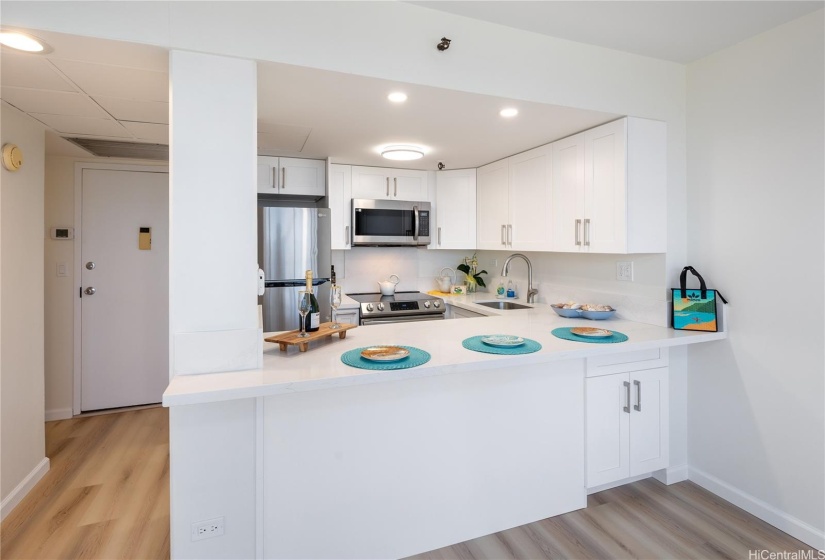 Cabinets, Sink, Stainless appliances, breakfast bar with recessed led ceiling lights, and storage under the counter.