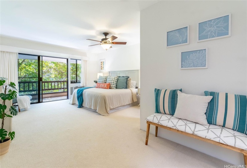 Spacious primary bedroom includes its own covered lanai overlooking the treetops of Mid Pacific Golf Course.