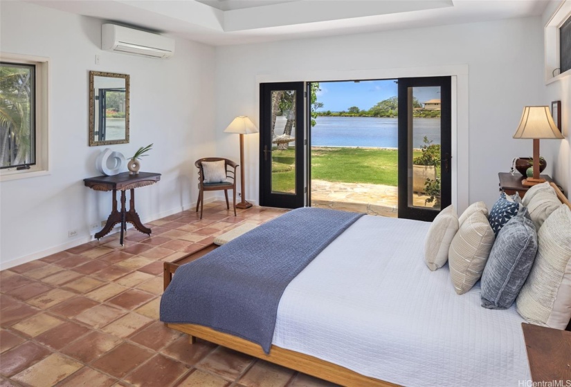 Primary bedroom with doors leading to the backyard, pool and lagoon.