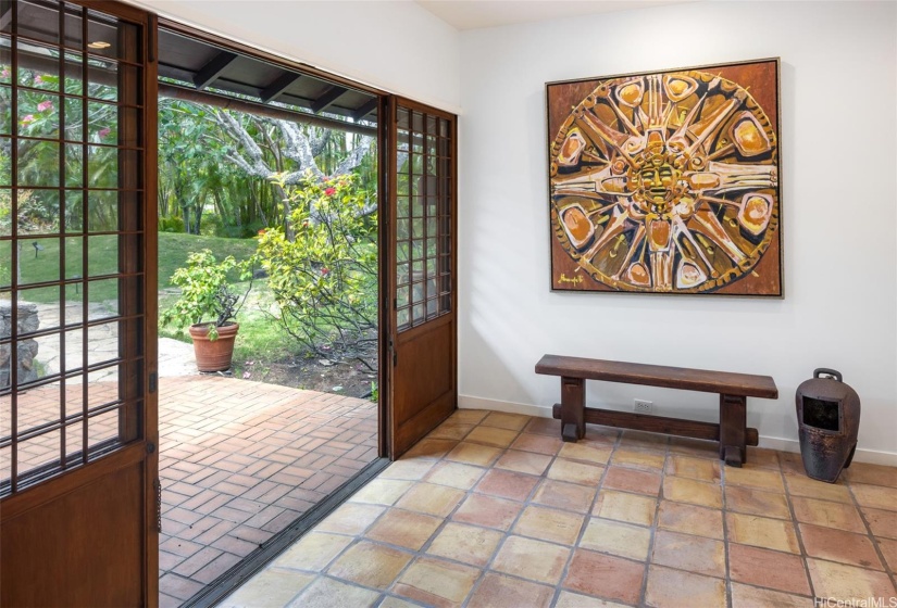 Walk down the lane of plumeria trees to the  classic sliding wooden doors at the entryway.