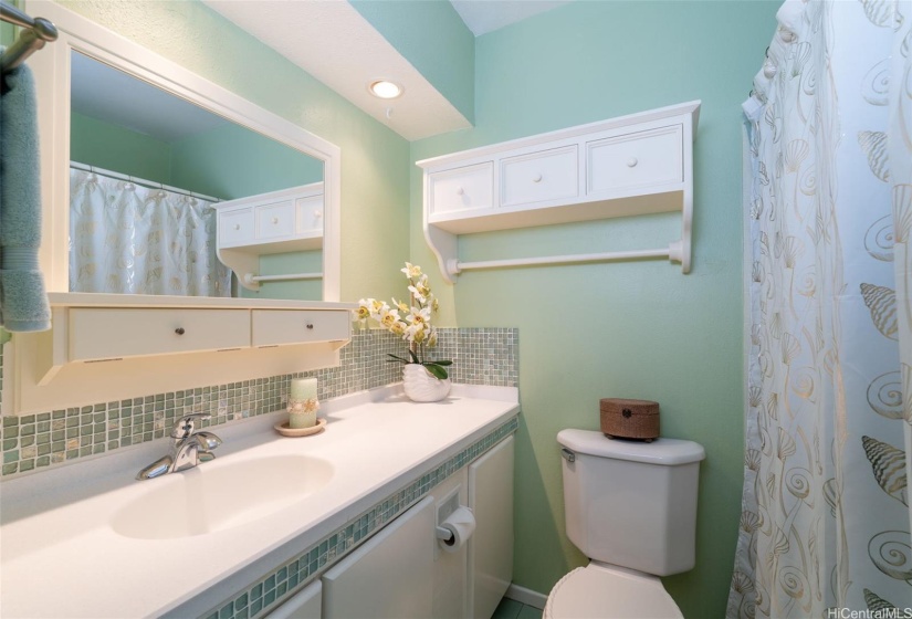 Main full bathroom on second floor with glass tile backsplash and Corian countertop