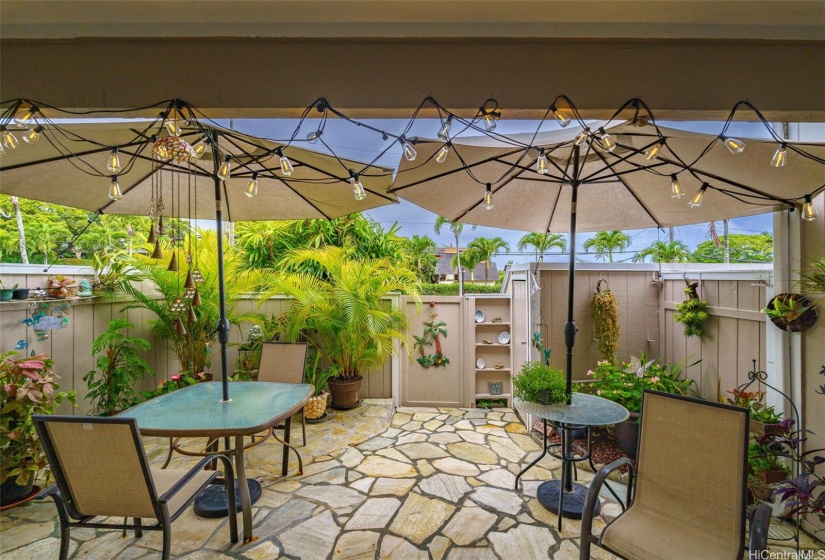 Beautiful and serene lanai space for outdoor dining and relaxing.  One of two storage sheds picturerd in right corner.