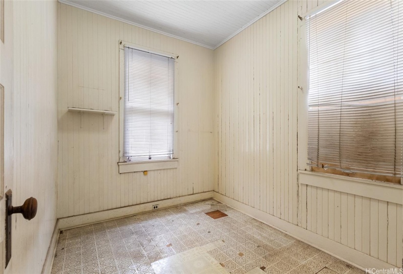 Looking into the back left side bedroom. Hardwood can be seen under the vinyl tiles.