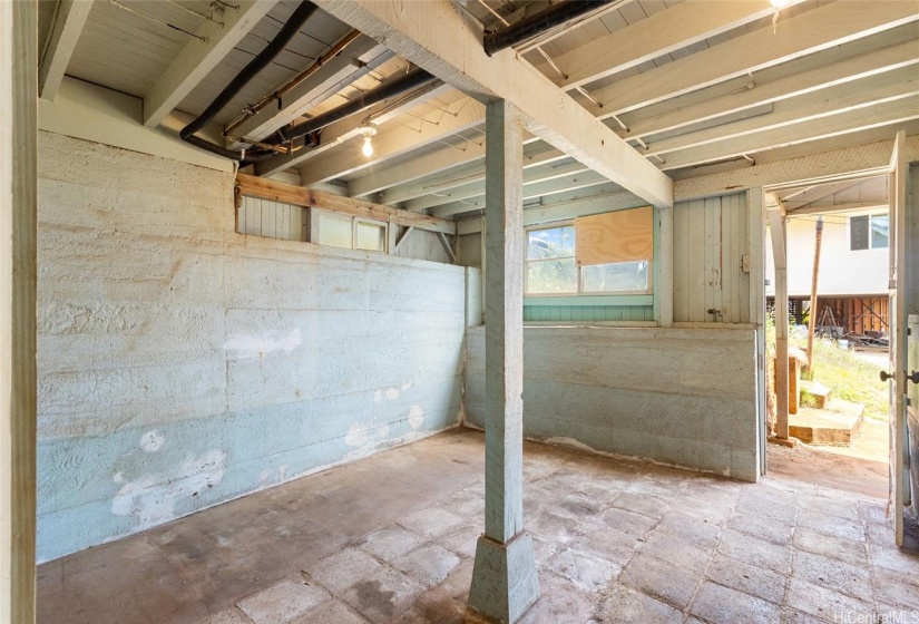 Another view of the basement area next to the carport. Notice the stone paver flooring and extra thick solid concrete walls...