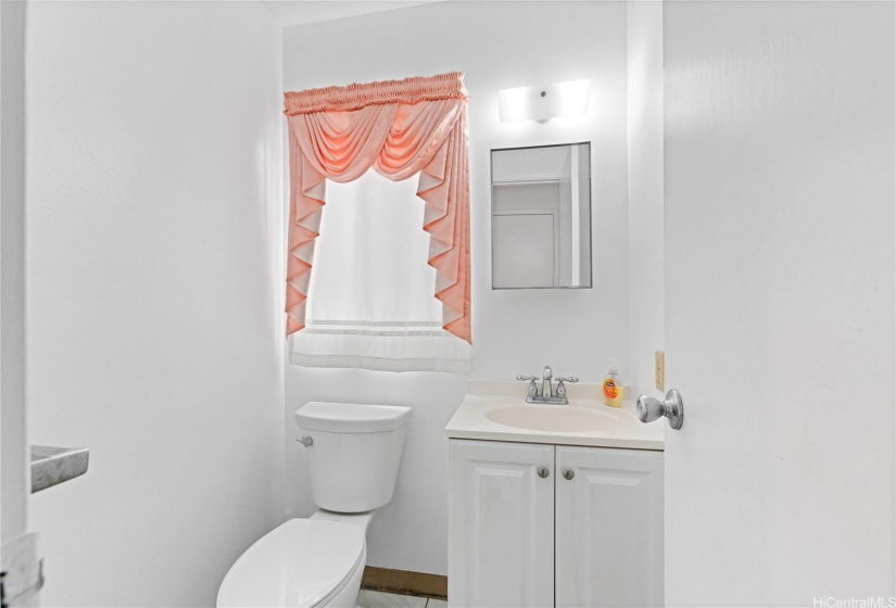The half bathroom is positioned between the two main living spaces for convenient access.