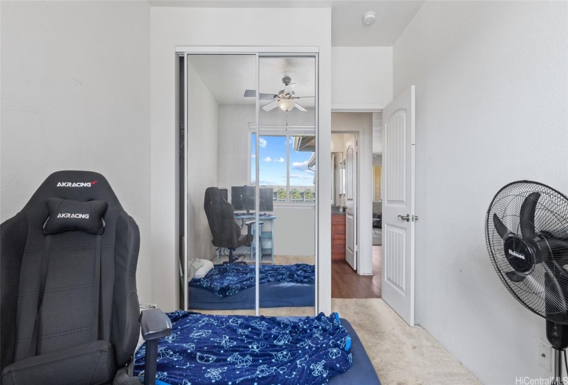 Large mirrored closet doors reflect the bright sun light in this room.