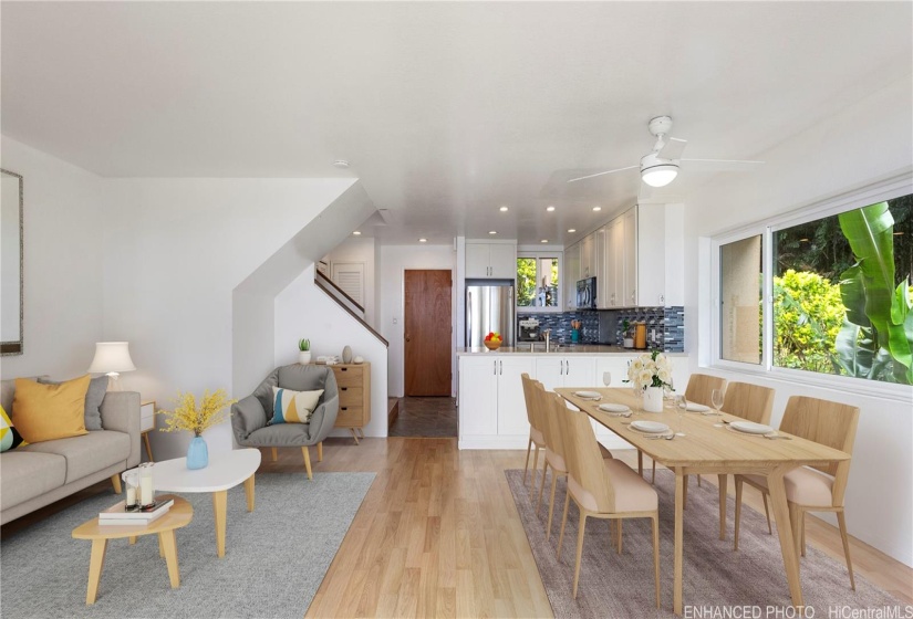 Virtually Staged Living Room view into kitchen, stairs, front door. Dedicated laundry room as well. Enhanced photo