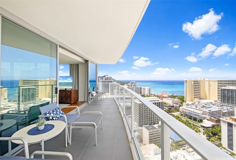 Spacious ocean side lanai leads from the living room to the primary bedroom.