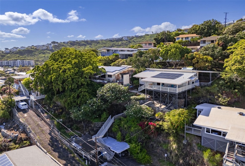 The 75 steps to your peaceful private perch are worth the daily workout and significantly increases home security! Plenty of outdoor space with two spacious covered lanais - 526 SF front and 496 SF back.  Aluminum roof with 18 owned PV panels and solar hot water.