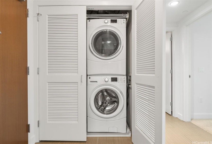 GE stack washer and dryer conveniently located in utility closet right inside front door.