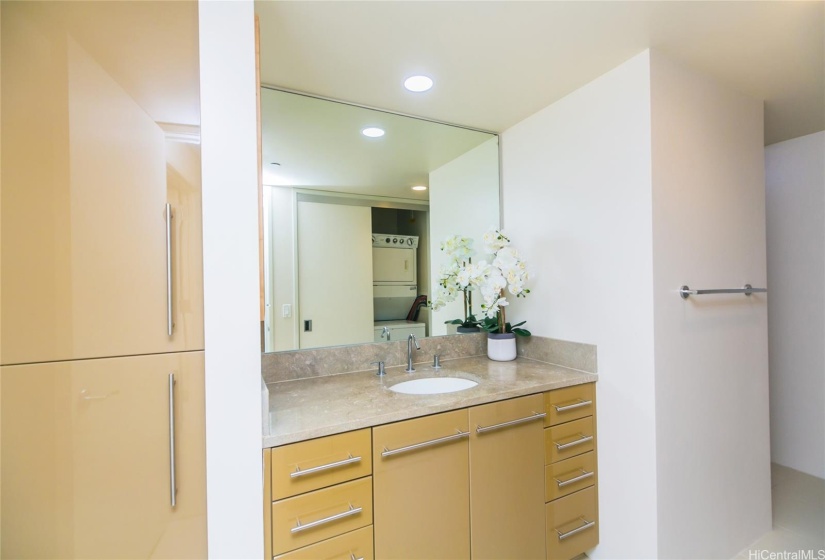 Second full bathroom, with ample cabinets for toiletries, stack washer/dryer, and shower.