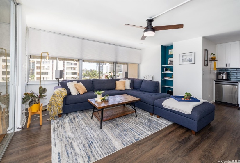 LARGE LIVING ROOM OF WINDOWS AND GLASS DOORS OPENS TO THE LANAI, BLINDS ON WINDOWS.