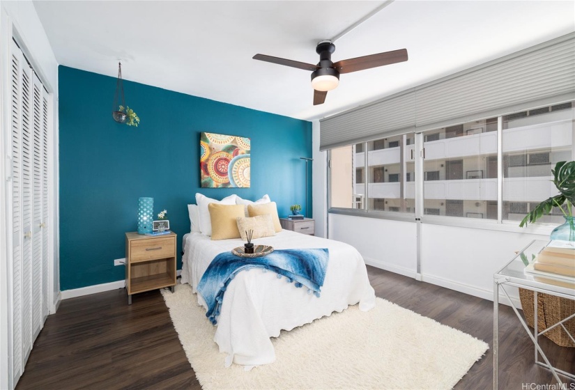 PRIMARY BEDROOM WITH LOTS OF NATURAL LIGHT AND CEILING FAN.