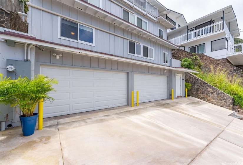 Curbside view. Two 2-car garages with 4 tandem driveway parking. Main entry to interior staircase leads to all three dwelling units.