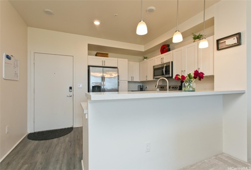 Modern kitchen located at the entrance of the Kohina at Ho'opili unit.