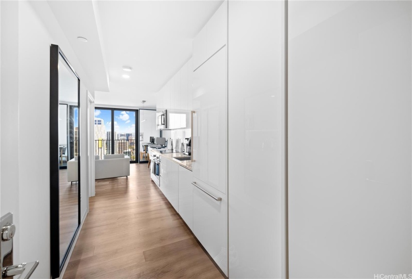 To the left the large cabinet neatly stores the washer and dryer.